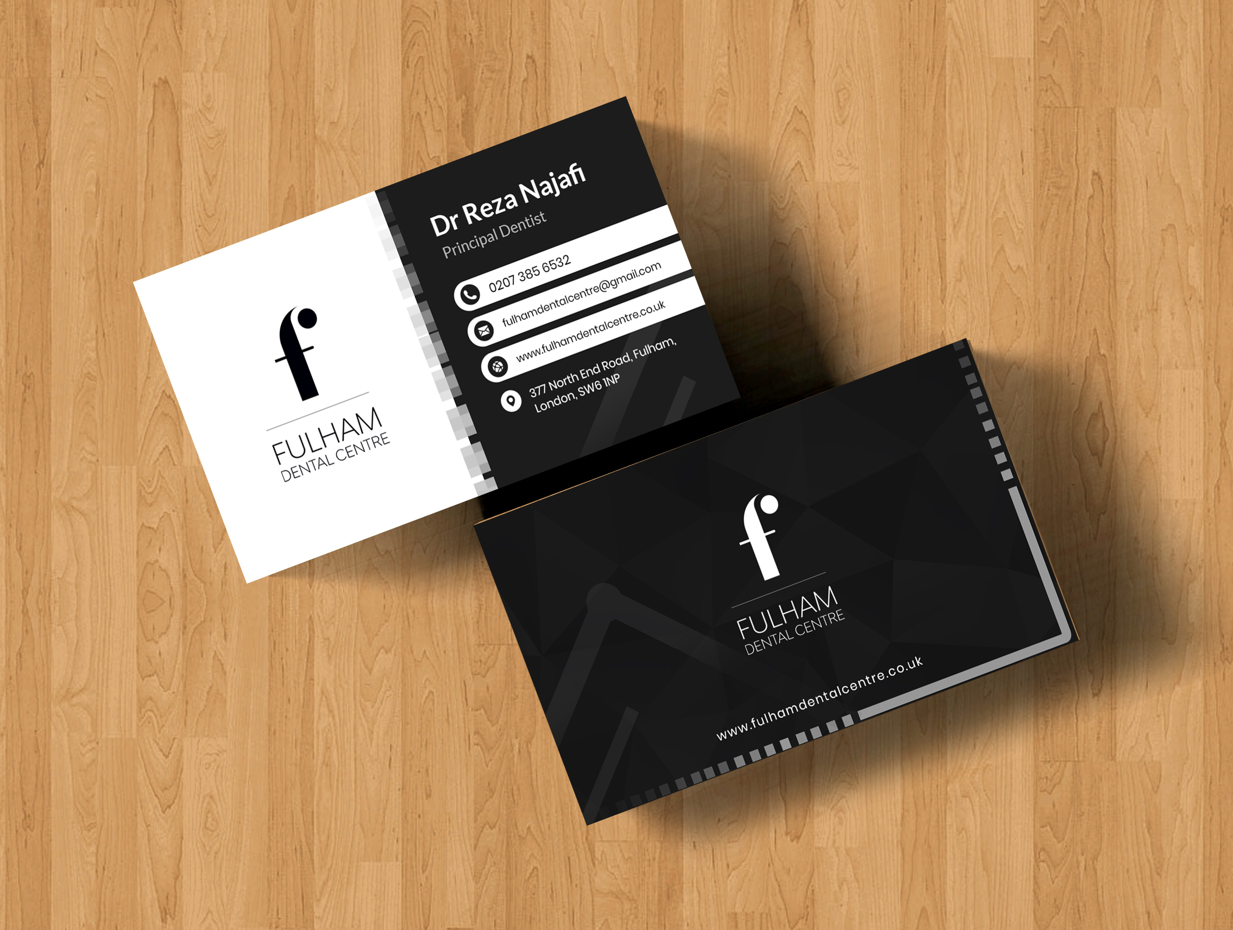 Fulham Dental Centre business cards on a wood desk — black side with white f-monogram and a subtle polygon texture; white side with black f-monogram and FULHAM DENTAL CENTRE wordmark