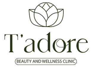 T'adore Beauty and Wellness Clinic primary mark — a fine line-art lotus above T'adore set in an elegant high-contrast display serif, with BEAUTY AND WELLNESS CLINIC inside a thin rounded-pill outline beneath
